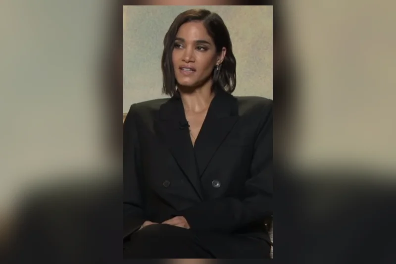 Sofia Boutella en blazer noir avec cheveux courts ondulés et regard direct d'interview