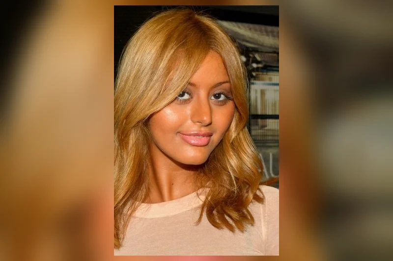 Zahia Dehar aux cheveux blonds ondulés, maquillage lumineux et haut clair