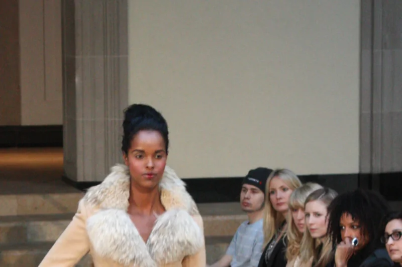 Ayan Elmi defilant en manteau creme a col fourrure lors de la Fashion Week de Toronto